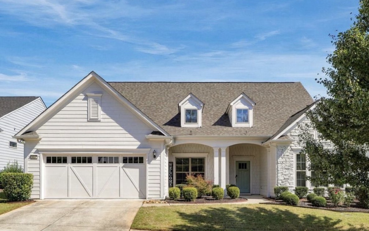 White single-level home with carriage garage door in Del Webb Chateau Elan