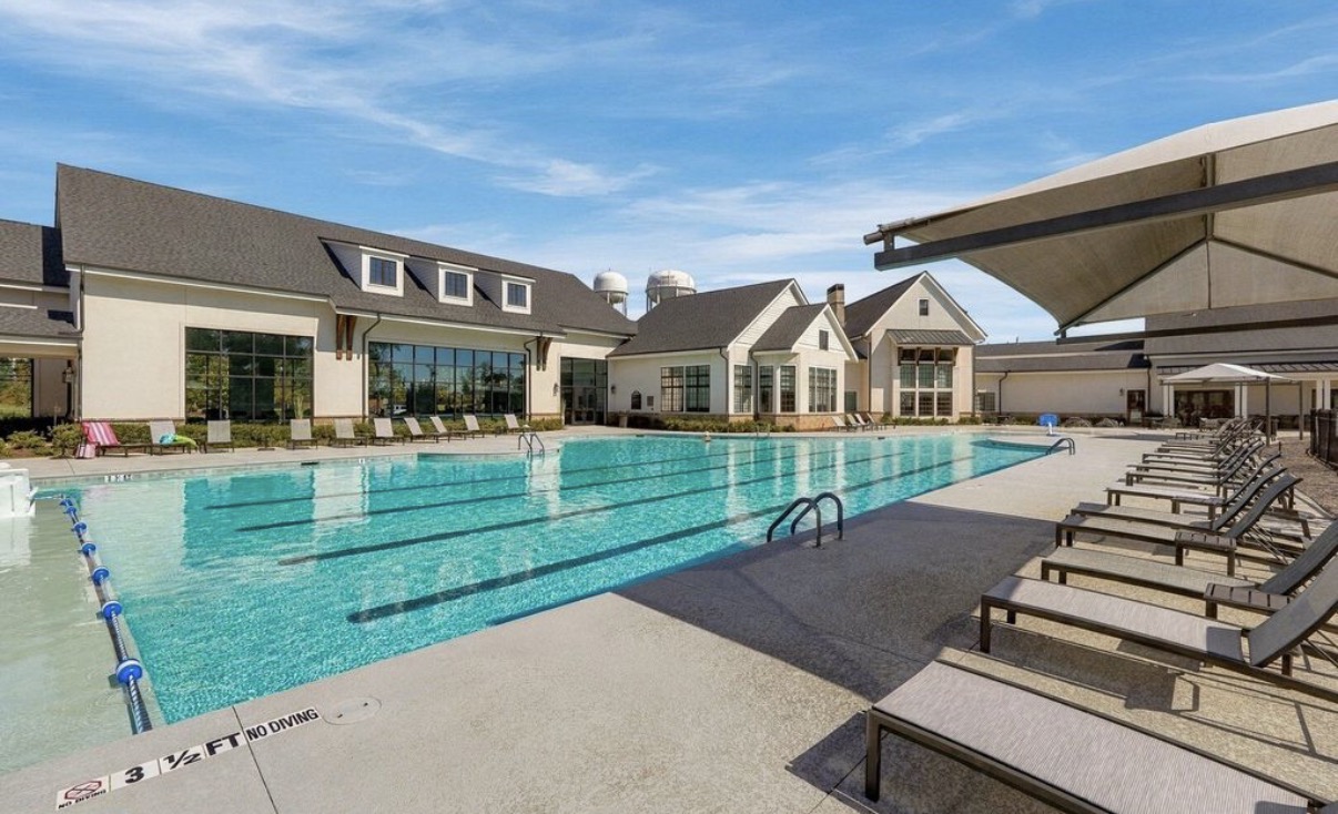 Outdoor pool with lap lanes and lounge chairs at Del Webb Chateau Elan