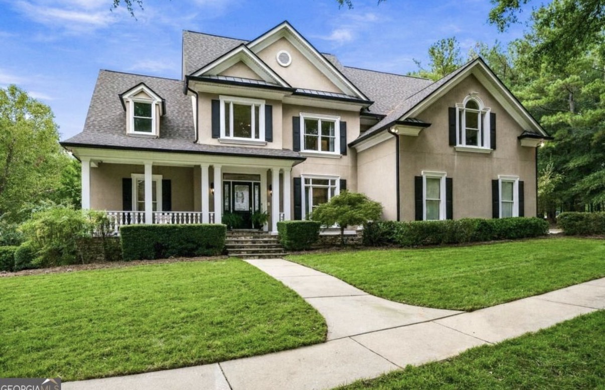 Stucco two-story home with front porch in Chateau Elan