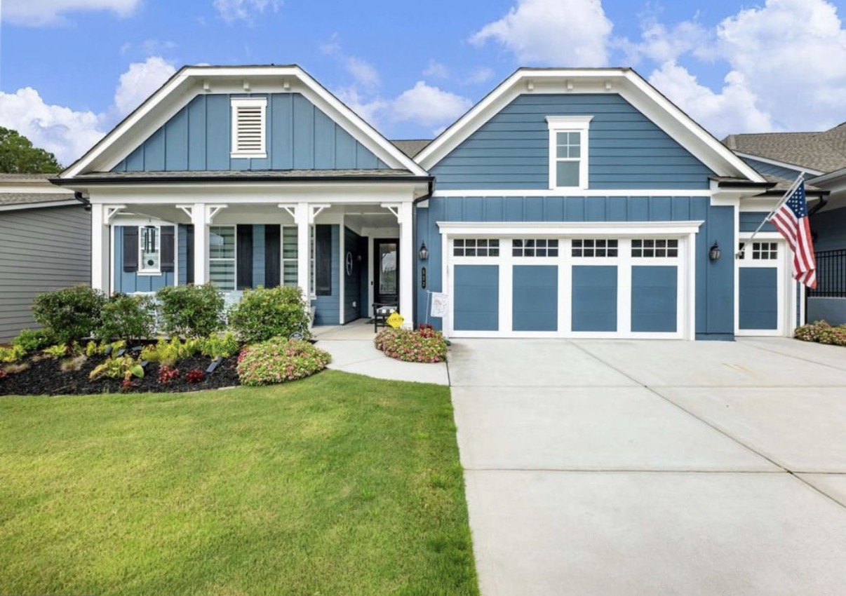 Blue craftsman ranch home with front porch in Cresswind at Twin Lakes