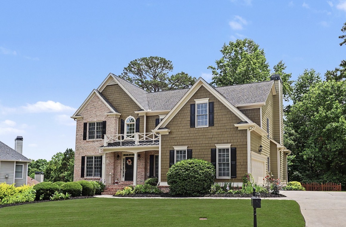 Two-story brick and shake home with black shutters in Hamilton Mill